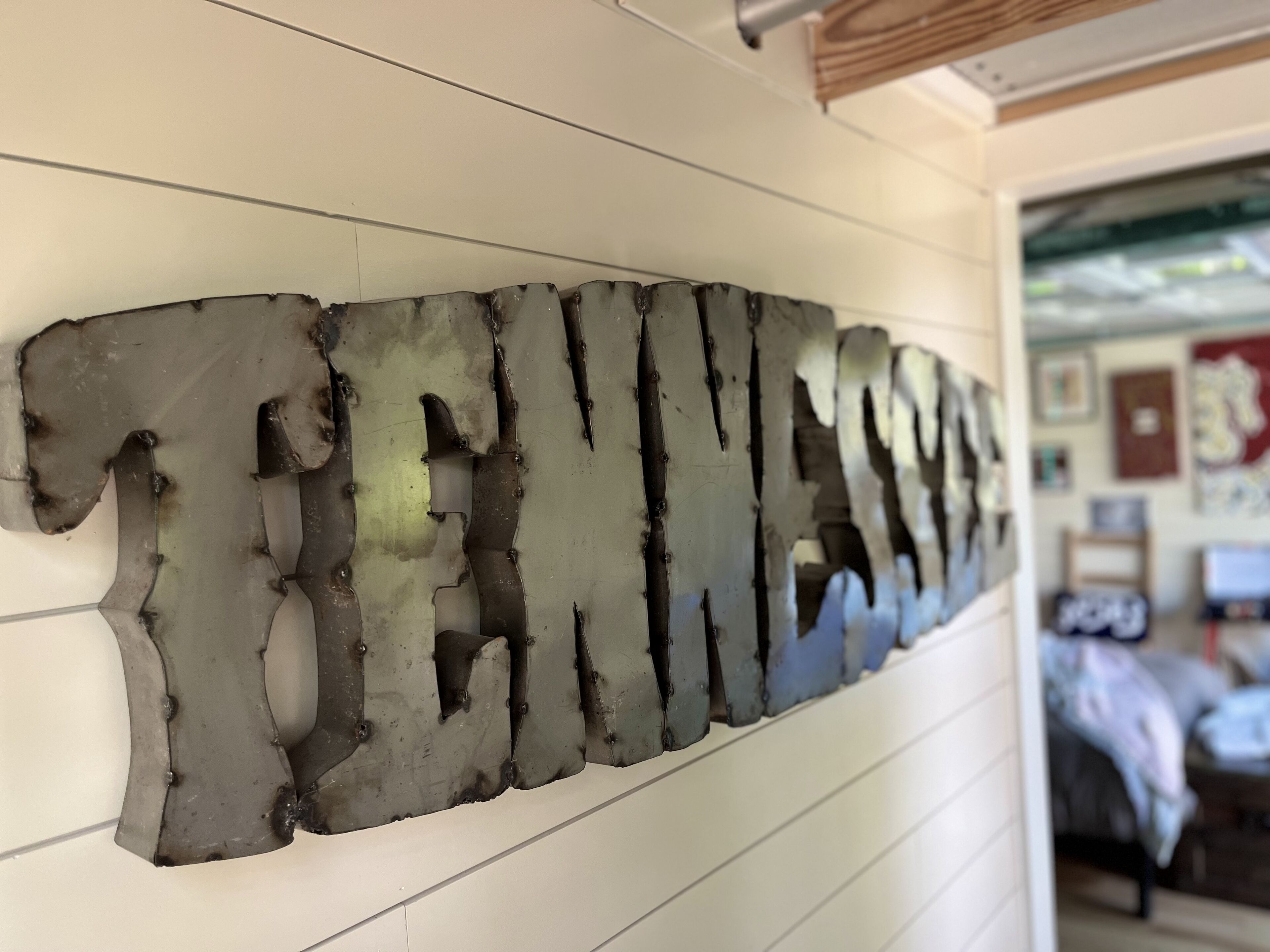 Un mur orné d’une grande enseigne métallique de forme irrégulière.