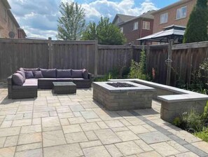 Relax in a patio area with a cozy fire pit and comfortable seating.