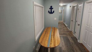 A hallway with a wooden bench, light blue walls, and a ceiling light fixture. - Minutes to Walnut Beach, newly renovated 3 bedroom home (Milford)