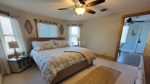 Una camera da letto con un letto, una ventola a soffitto e un tappeto.