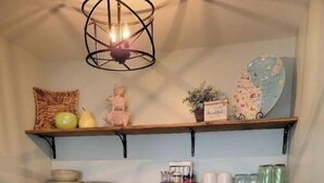 Una cucina compatta con lavandino, macchina del caffè, tostapane e frigorifero.