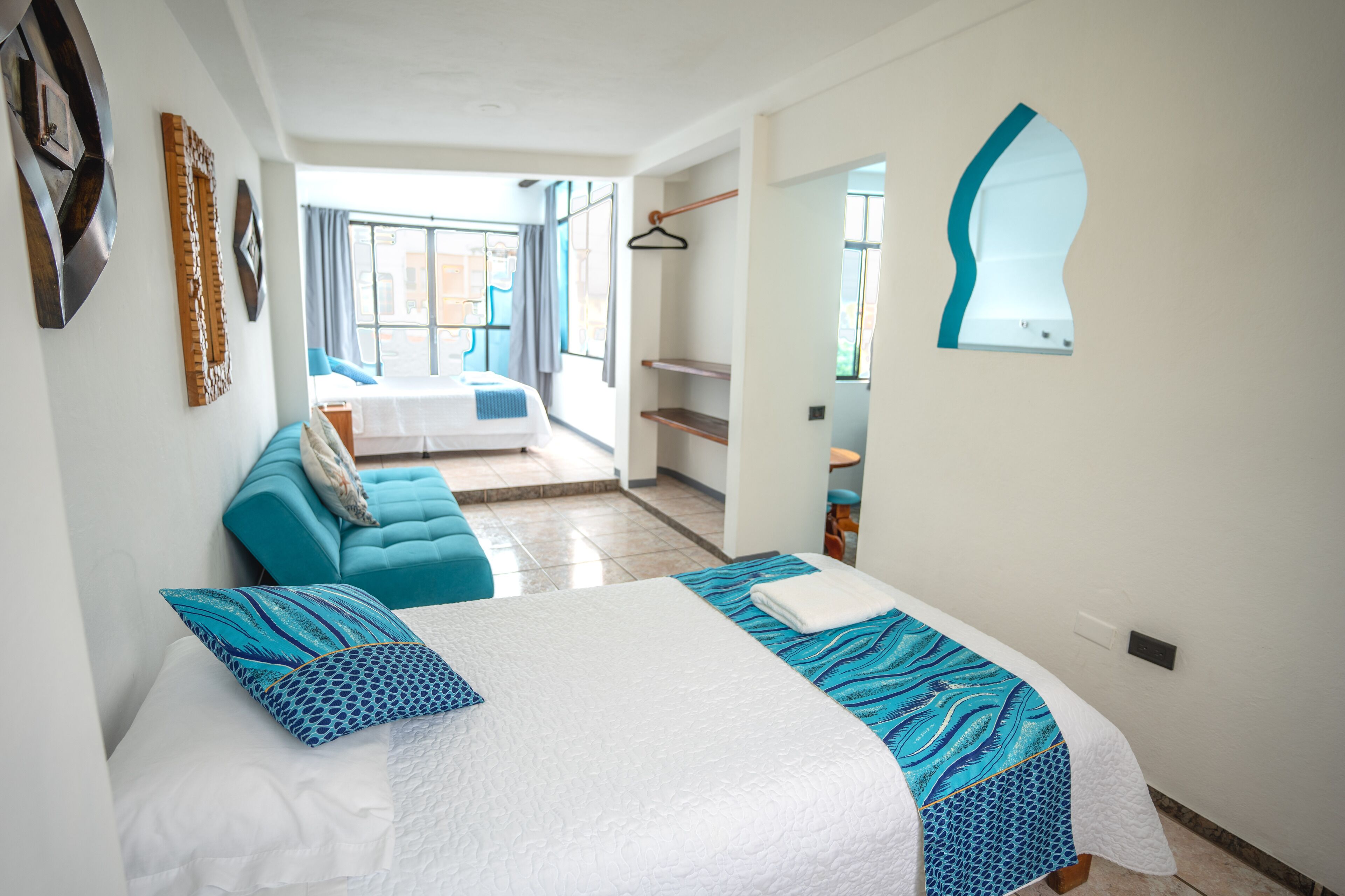 Een moderne hotelkamer met een groot bed, een bank en uitzicht op de omgeving.