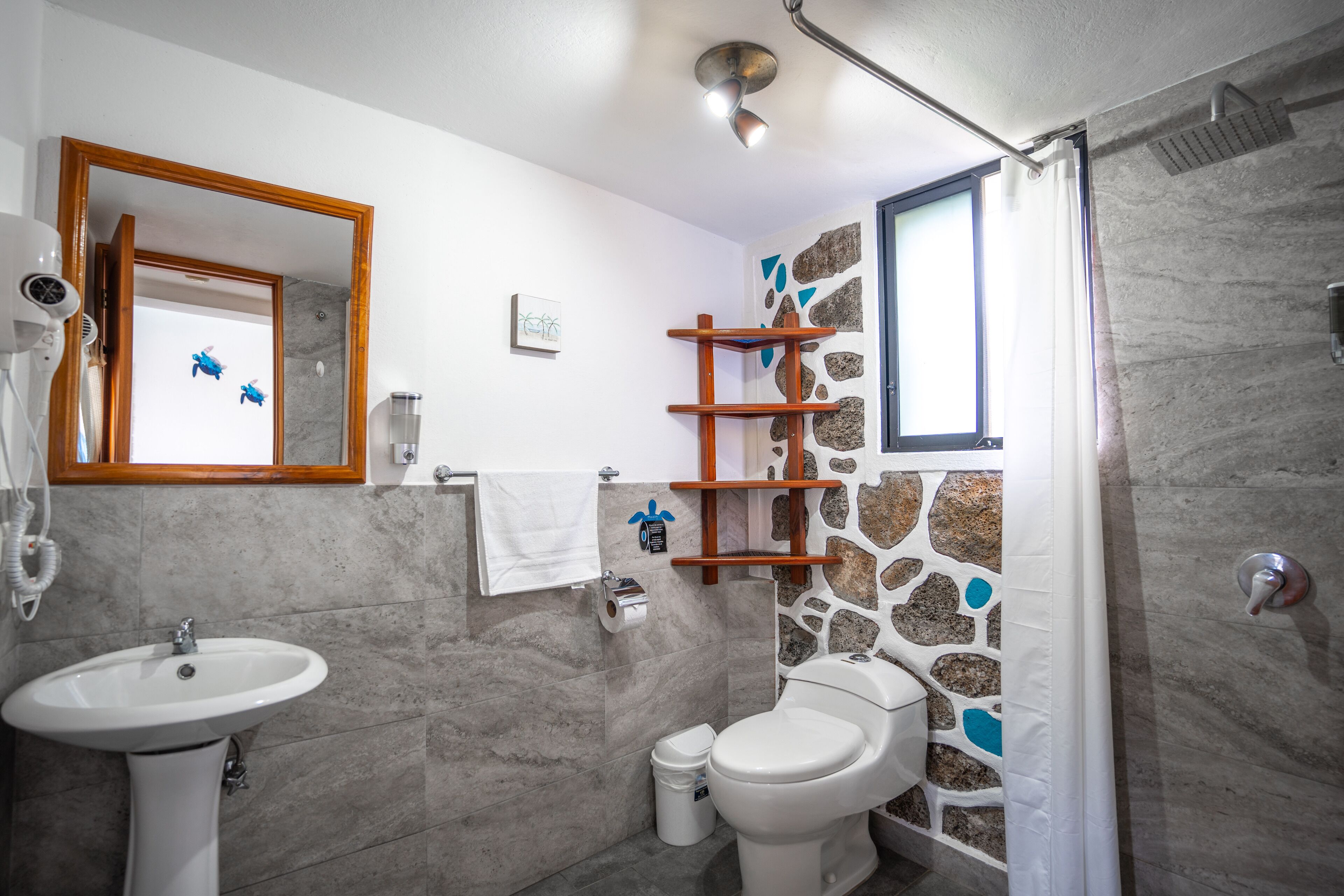 A bathroom with a sink, toilet, and shower area.