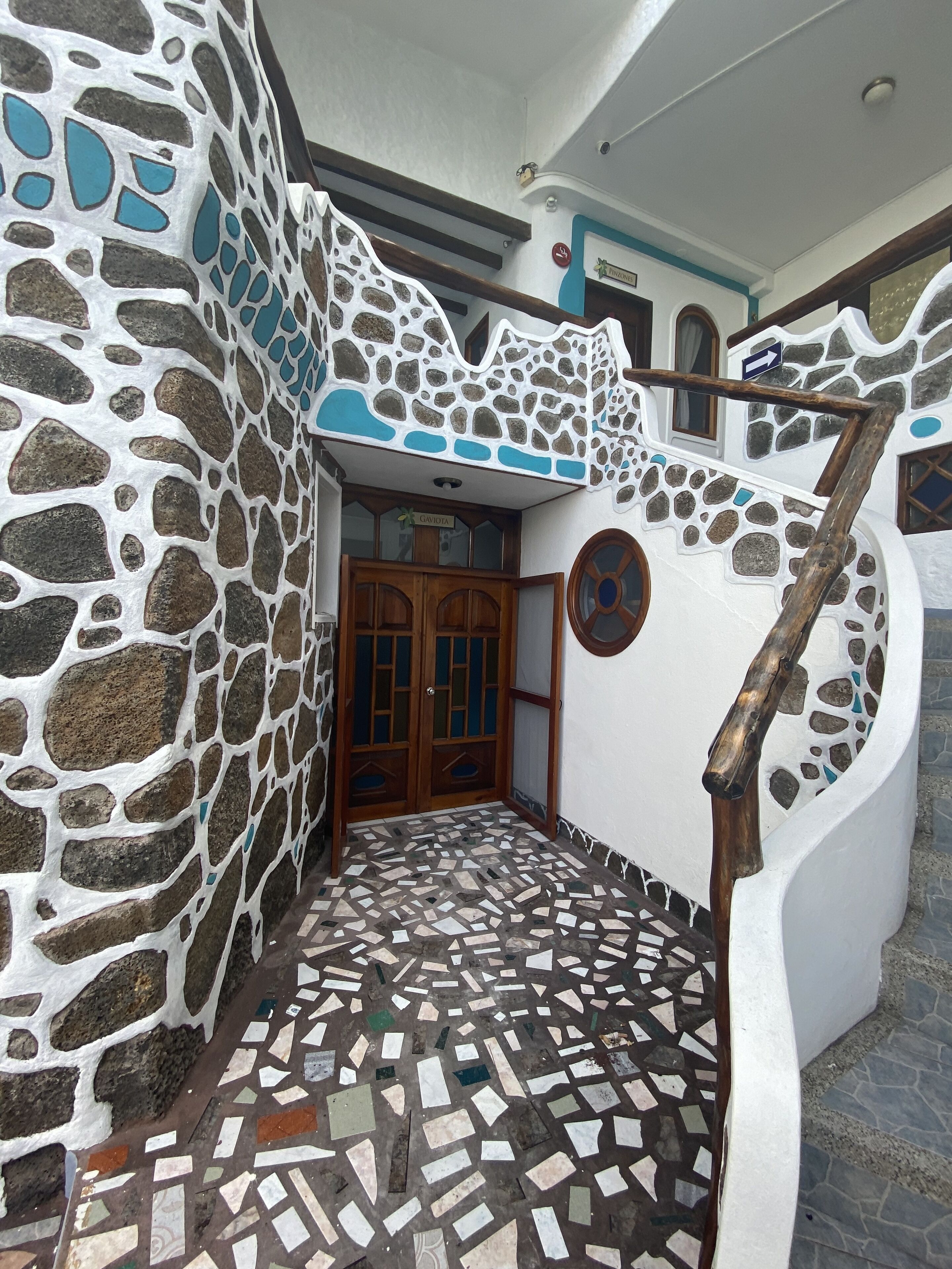 Un bâtiment doté d’une façade en pierre, d’un sol en mosaïque et d’un escalier en bois.
