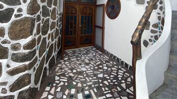 Un bâtiment doté d’une façade en pierre, d’un sol en mosaïque et d’un escalier en bois.