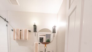 Un baño con inodoro, lavamanos y espejo.