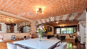 A spacious dining area with a brick ceiling, a white table, and four chairs. - Mi Zona Lodging Coyoacán (Mexico City)