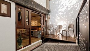A modern interior with a brick wall, a wooden bench, and a table with chairs. - Mi Zona Lodging Coyoacán (Mexico City)