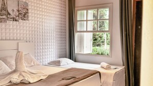A hotel room with a bed, a window with curtains, and a wall with a geometric pattern. - Pousada Casa de Campos Capivari by Concavus (Campos do Jordão)