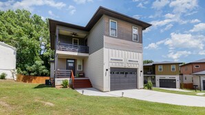 A two-story house with a balcony, a garage, and a well-maintained lawn. - New Modern Home in the heart of Downtown Durham (Durham)