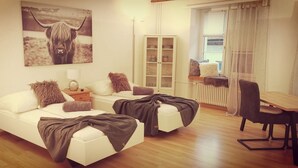 En moderne stue med sofasæt, spisebord og skab.