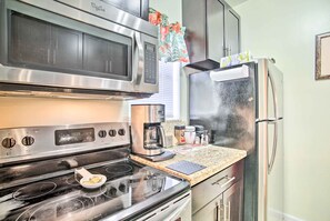 Enjoy cooking in this well-equipped kitchen with a microwave, oven, and refrigerator.