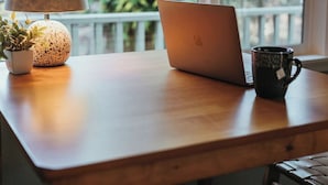 A wooden table with a laptop, a lamp, a potted plant, and a mug. - Iconic Union Skyhouse with Hood Canal views (Union)