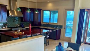 Una cocina moderna con armarios de madera oscura, electrodomésticos de acero inoxidable y una isla grande con asientos.