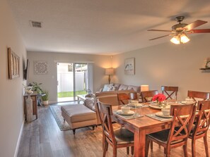 A dining area with a wooden table, chairs, and a ceiling fan. - So close to Disney you can feel the magic! (Kissimmee)