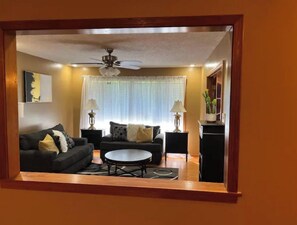 A living room with a sofa, coffee table, and two side tables with lamps. - Cozy Cove! Spacious and clean. (Covington)