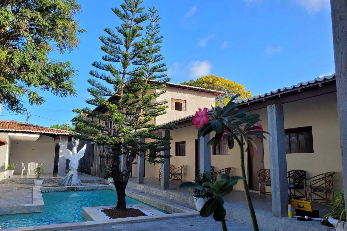 Ein Innenhof mit Schwimmbad, Brunnen und einem großen Baum.