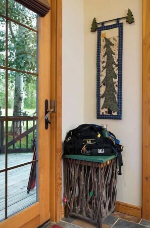 Enter a serene space with a door leading to an outdoor area, featuring a small table with personal belongings and a decorative wall hanging.