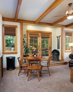 Relax in this spacious room with a high ceiling, large windows, and a comfortable seating area.