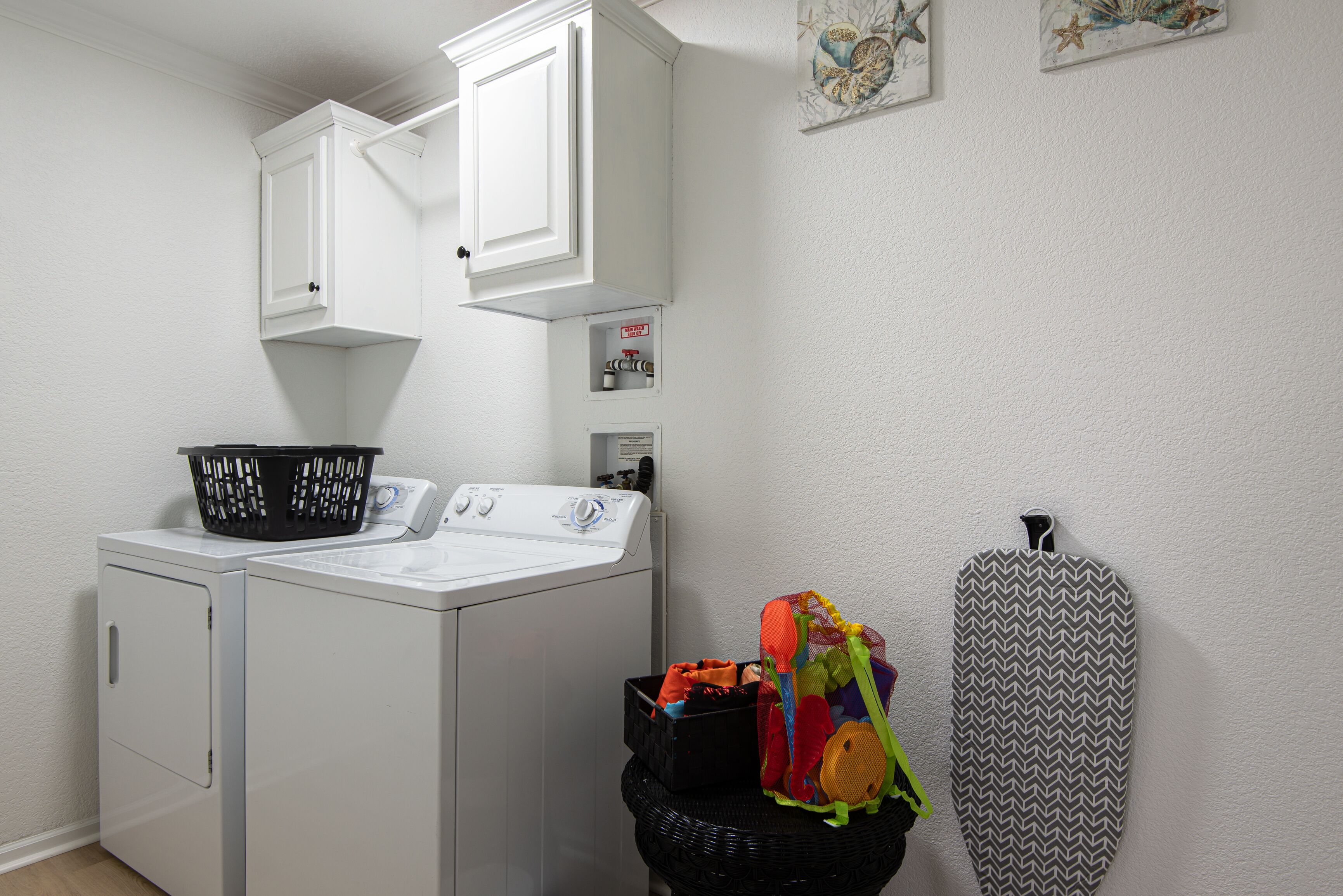 A laundry area with a washing machine, a dryer, and a basket of clothes.