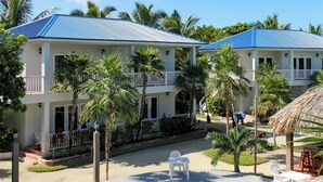 A resort with a swimming pool, two-story buildings, and palm trees.
