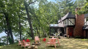 Een vakantiehuis aan een meer met een huis in Tudostijl, terras en vuurplaats.