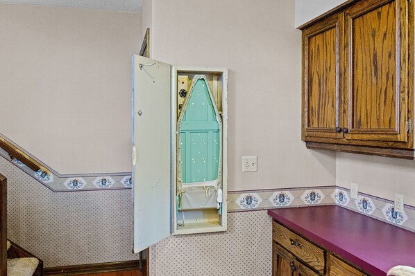 Una cocina con un mueble de madera, encimera morada y salpicadero con diseño.