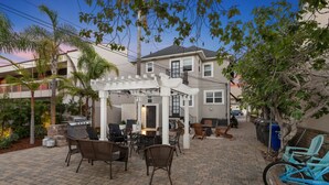 A patio area with outdoor furniture, a grill, and a pergola.