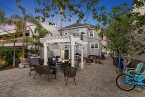 Un patio con mobiliario exterior, una pérgola y una bicicleta.