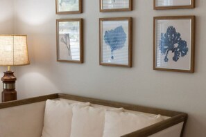 Una habitación con una cama, una lámpara y cuatro cuadros en la pared.