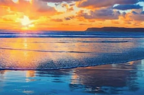 Escena de playa con atardecer.