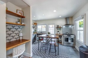A modern kitchen with a central island, stainless steel appliances, and a patterned backsplash.