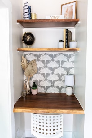A wooden shelf unit with decorative items, a globe, and a patterned wall.