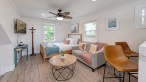 A modern bedroom with a bed, a sofa, a coffee table, and a ceiling fan. - Unit C - B Ave Bungalows · Surf Shack Studio, 5 Min Walk to Coronado Beach! (Coronado)