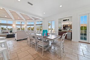A spacious kitchen with a dining area, large windows, and a view of the outdoors.
