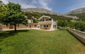 Enjoy a serene outdoor space with a balcony overlooking the surrounding hills and lush greenery.