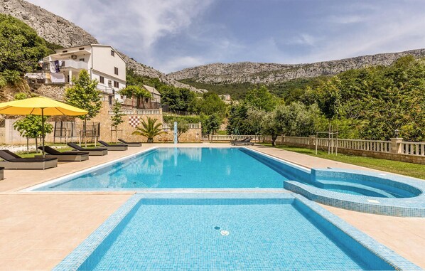 Relax by the pool surrounded by lush greenery and mountain views.