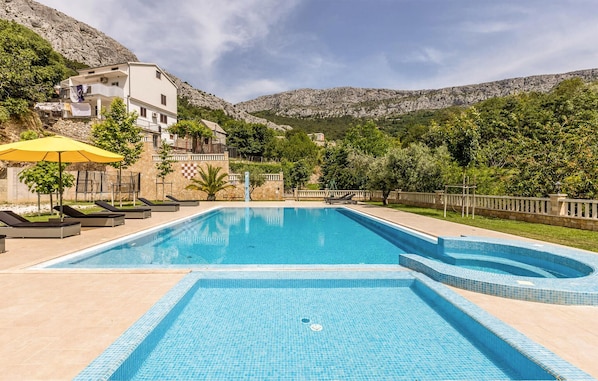 Relax by the pool surrounded by lush greenery and mountain views.