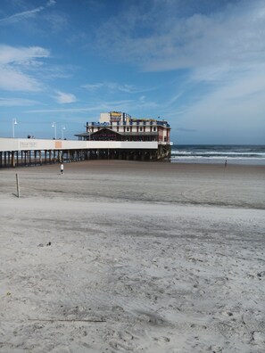 A pier extending into the ocean with a building featuring a sign that reads "Eat at Joe's." - OCEAN FRONT STUDIO with 2 full beds & kitchenette (Daytona Beach)