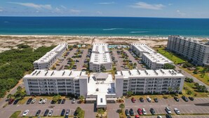 Een resort met meerdere gebouwen, een parkeerplaats en een strand.