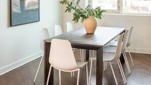 Un espace repas comprenant une table, des chaises, un luminaire suspendu et une plante.