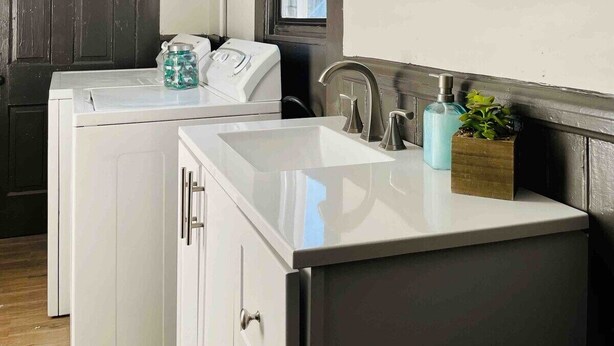 Una cocina moderna con un ventanal grande, electrodomésticos integrados y un accesorio decorativo sobre el fregadero.
