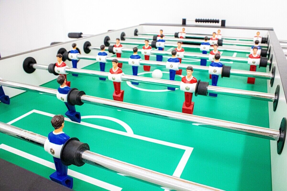 Un tavolo da calcio con diversi giocatori e un pallone da calcio.