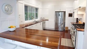 Eine moderne Küche mit weißen Schränken, einem Edelstahlkühlschrank und einer Holz Arbeitsplatte.