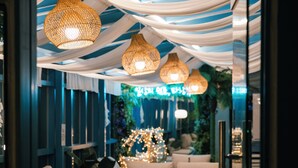 Un interior moderno con sofás, lámparas colgantes, un árbol de Navidad y una pared azul.