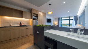 Una cocina moderna con armarios de madera, un microondas integrado y un ventanal amplio.