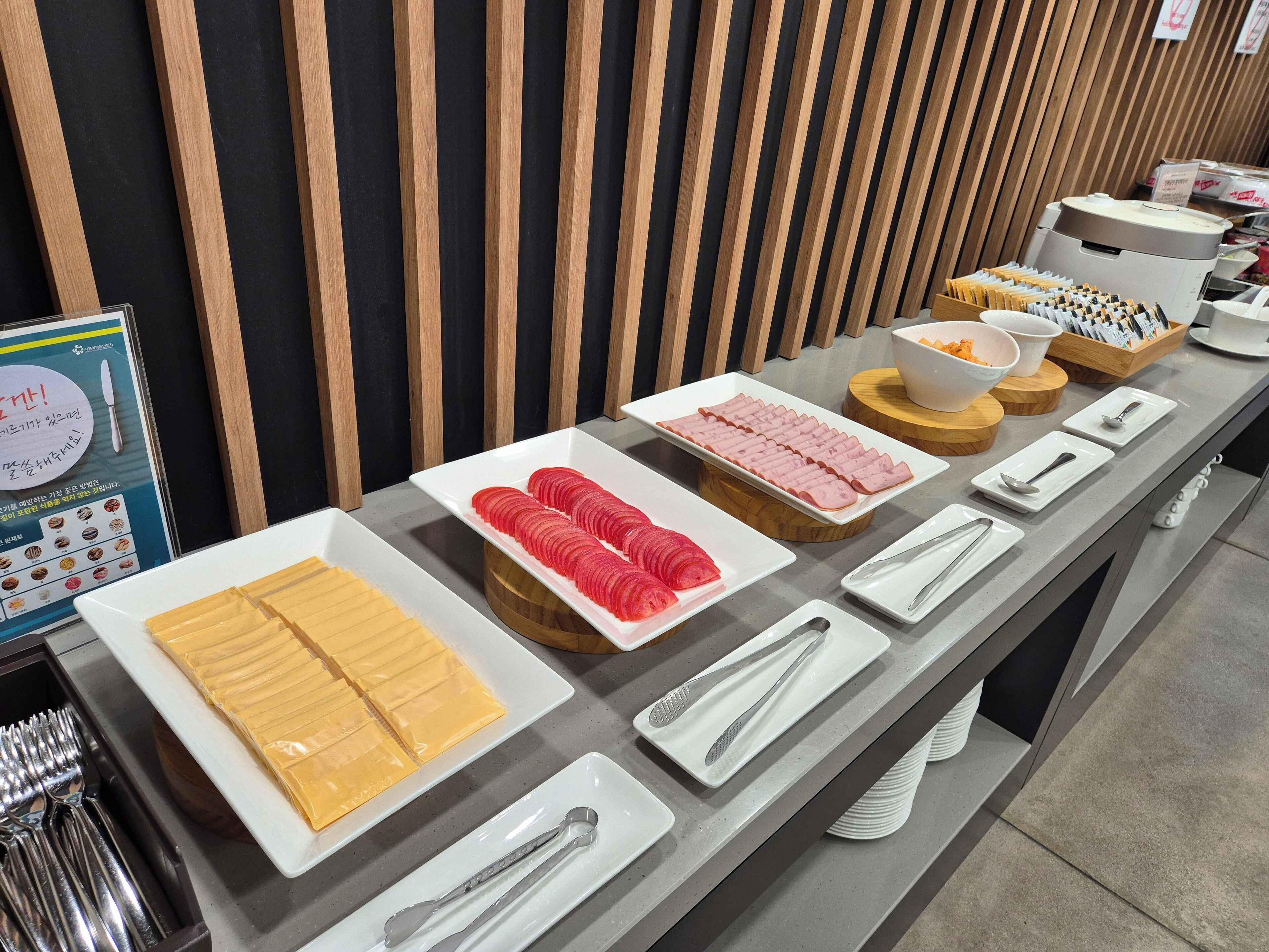 A buffet setup with various food items and utensils.