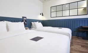 Een hotelkamer met twee bedden, een bureau, een spiegel en een telefoon.