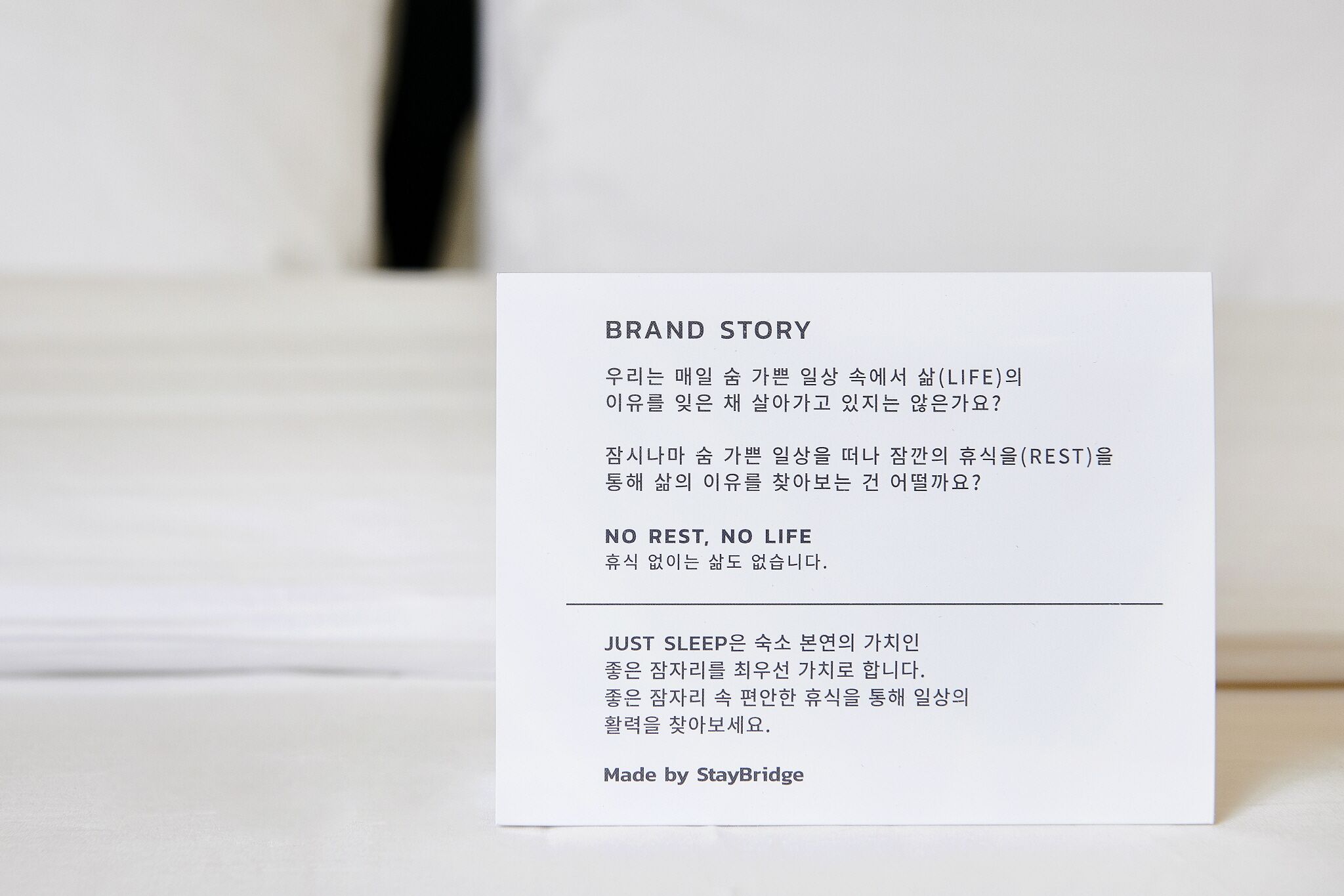 Tarjeta blanca con texto en coreano que relata la historia de una marca relacionada con el descanso y el sueño.