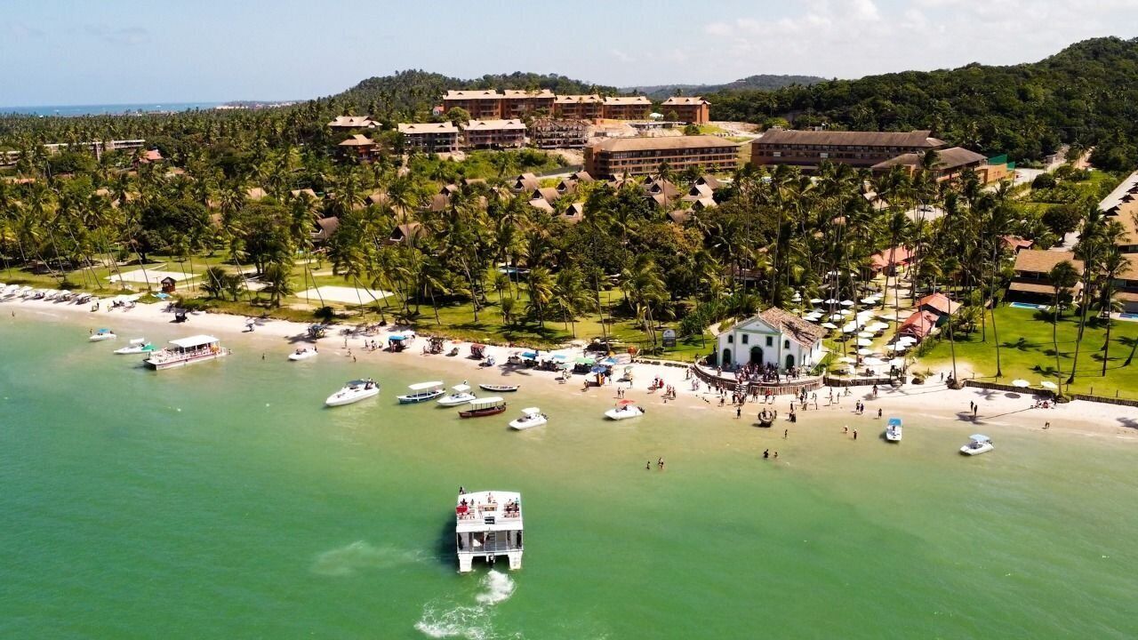 Na praia, areia branca, espreguiçadeiras, guarda-sóis 